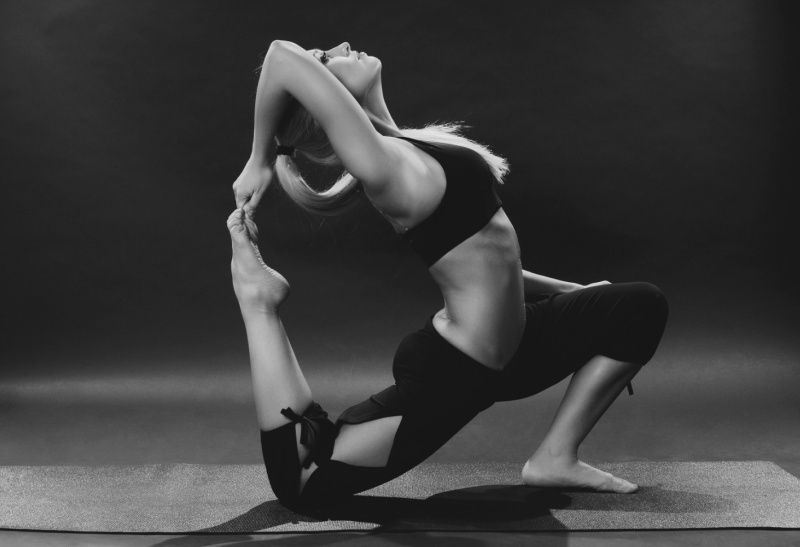 Kvinna utför en avancerad dynamisk yogaposition på en matta